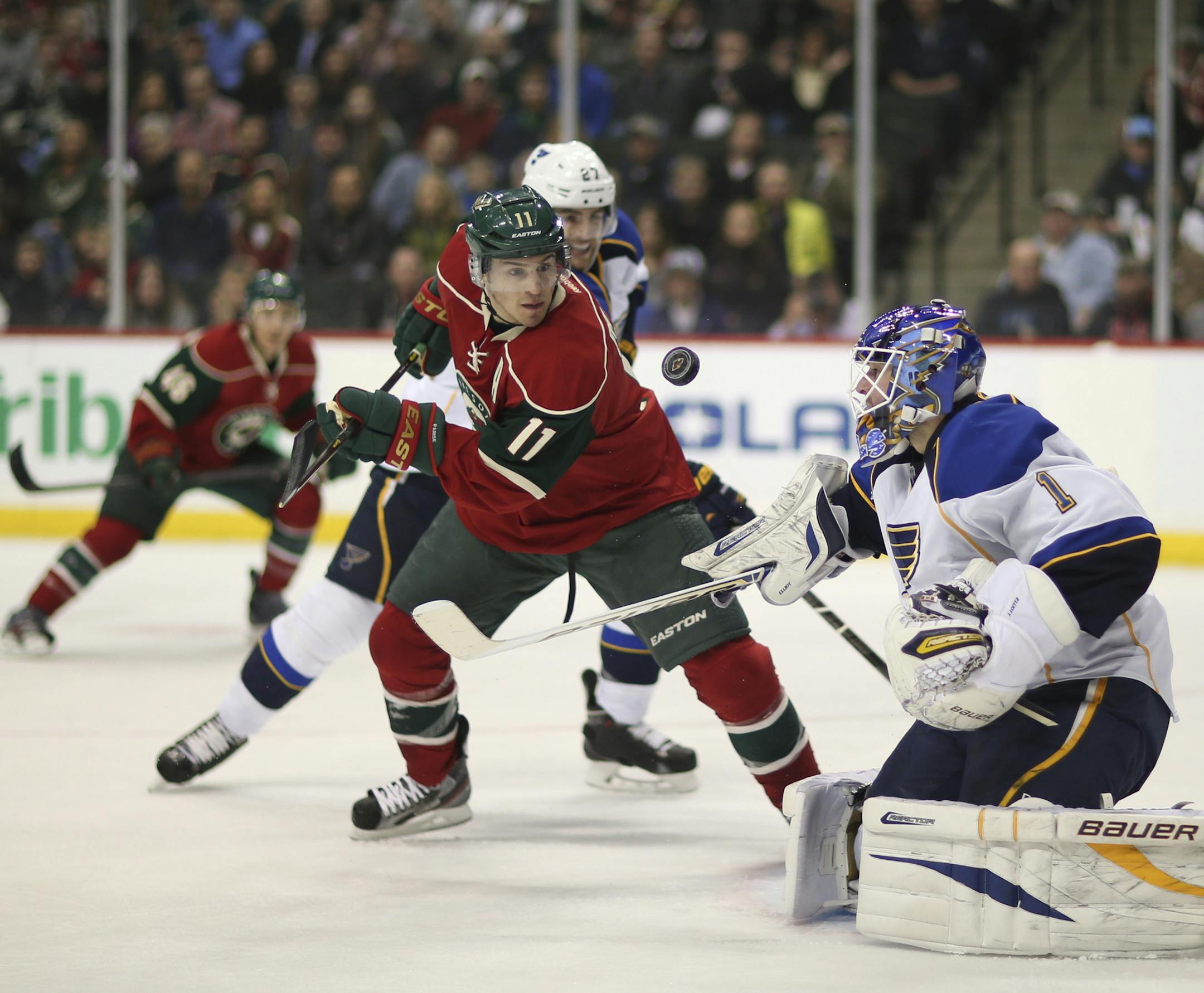 Zach Parise and St. Louis goaltender Brian Elliott kept their eyes on a flying puck in the first period