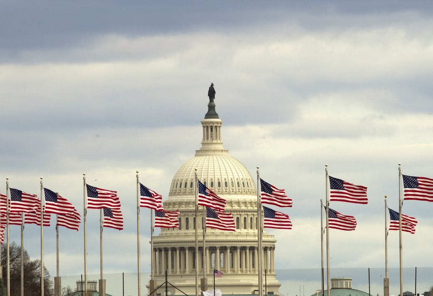 Flags fly in front of the U.S. Capitol in Washington, Tuesday morning, Jan. 1, 2019, as a partial government shutdown stretches into its third week. A high-stakes move to reopen the government will be the first big battle between Nancy Pelosi and President Donald Trump as Democrats come into control of the House.