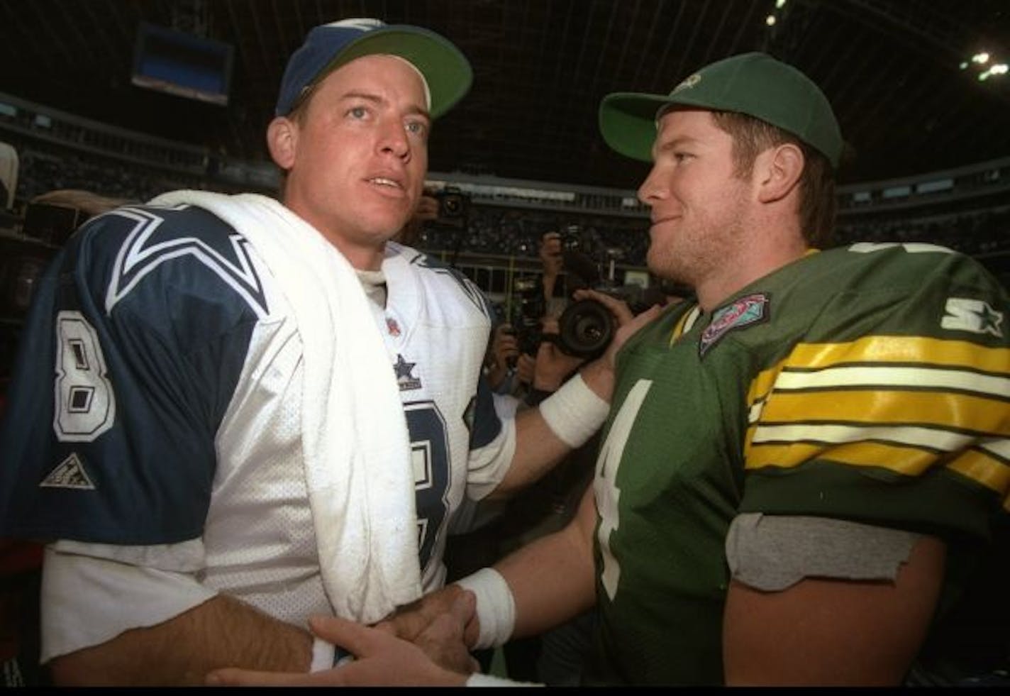 Quarterback Troy Aikman of the Dallas Cowboys (left) confers with Green Bay Packers quarterback Brett Favre after a Jan 8, 1995 playoff game.