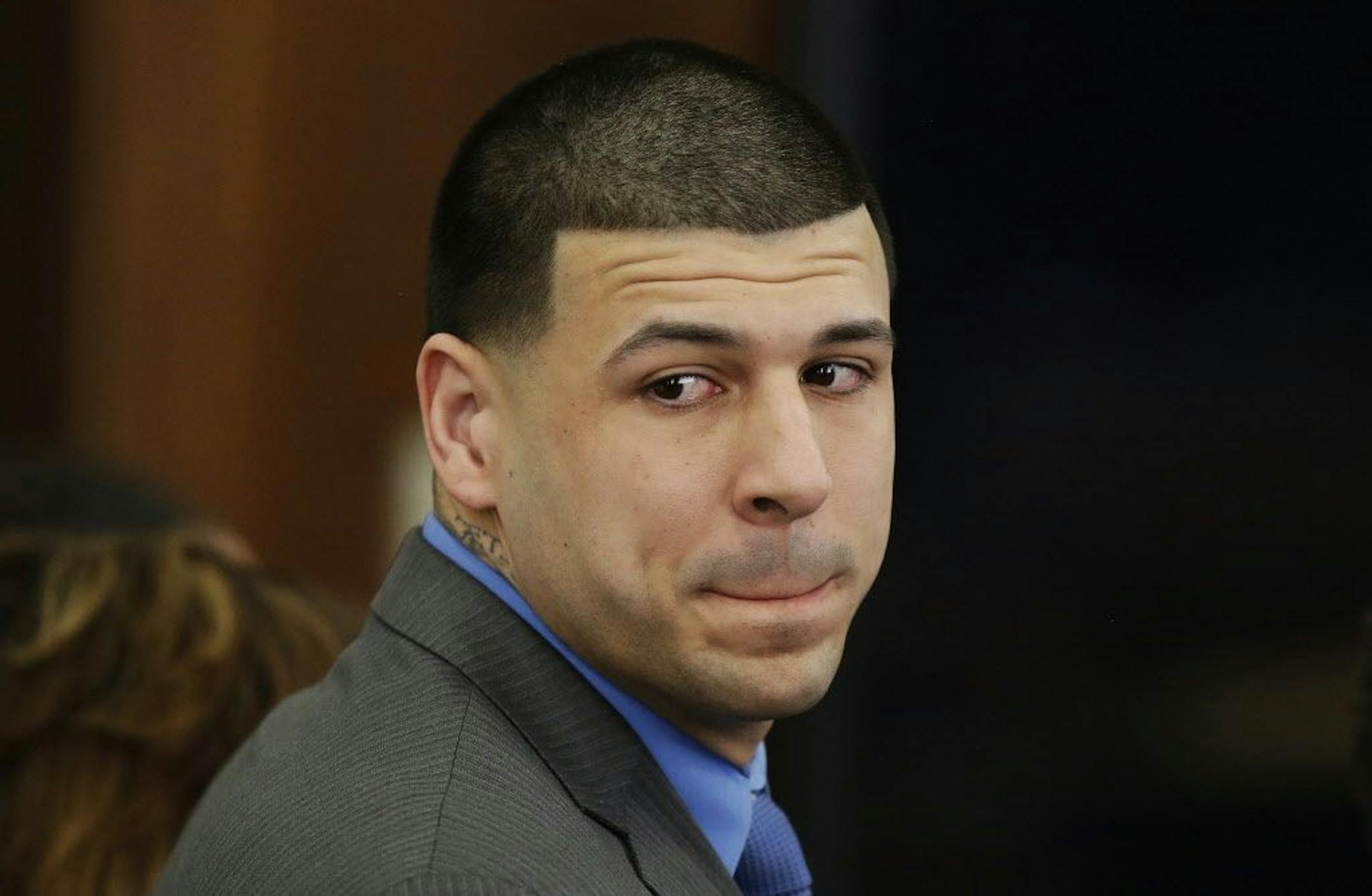 Former New England Patriots tight end Aaron Hernandez turns to look in the direction of the jury Friday as he reacts to his double murder acquittal at Suffolk Superior Court in Boston.