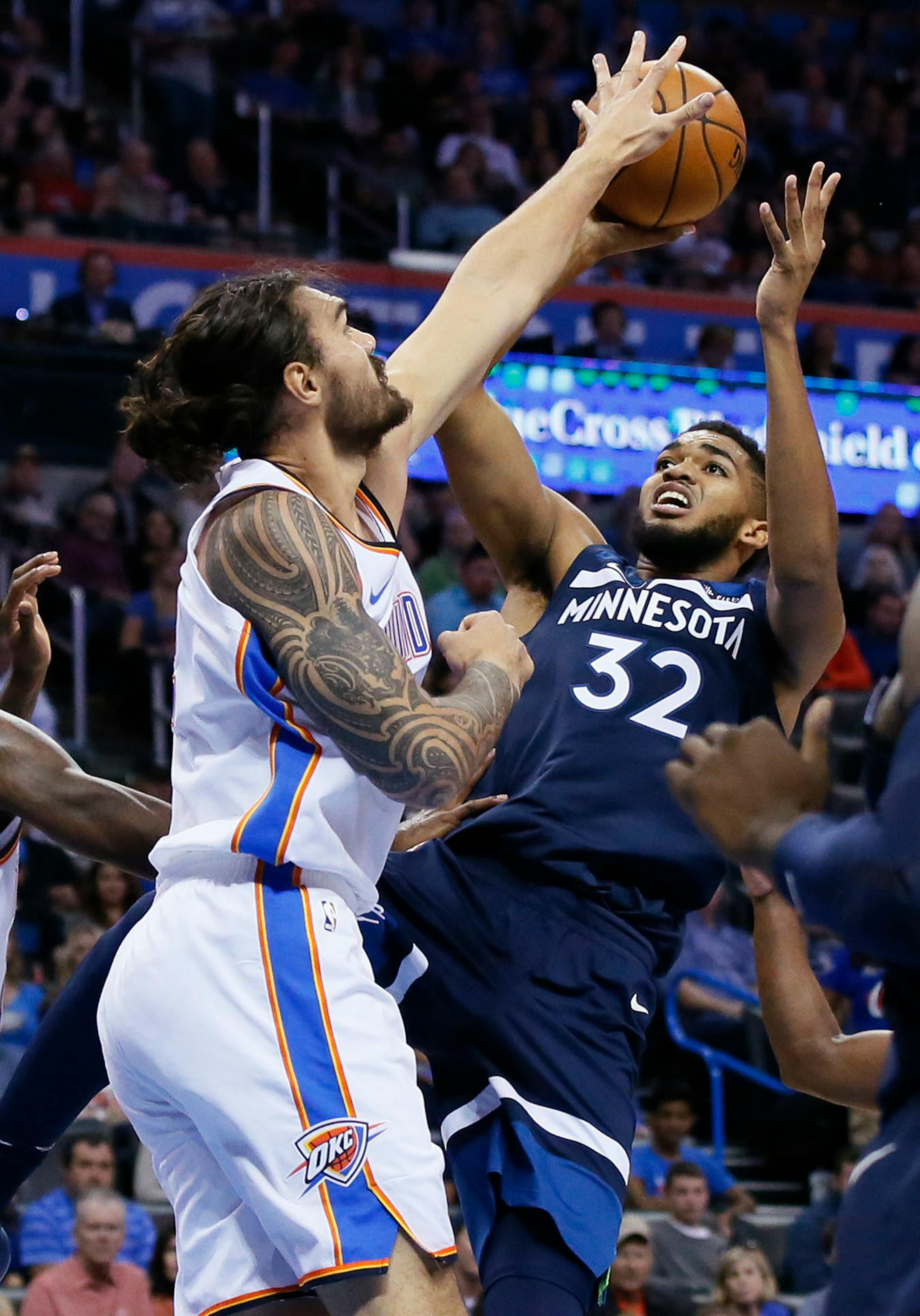 Oklahoma City Thunder center Steven Adams, left, blocks a shot by Minnesota Timberwolves center Karl-Anthony Towns (32) in the second quarter of an NBA basketball game in Oklahoma City, Sunday, Oct. 22, 2017.