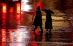 Pedestrians are silhouetted against wet pavement in Kansas City, Mo. Several factors have contributed to the increase in pedestrian deaths, including 