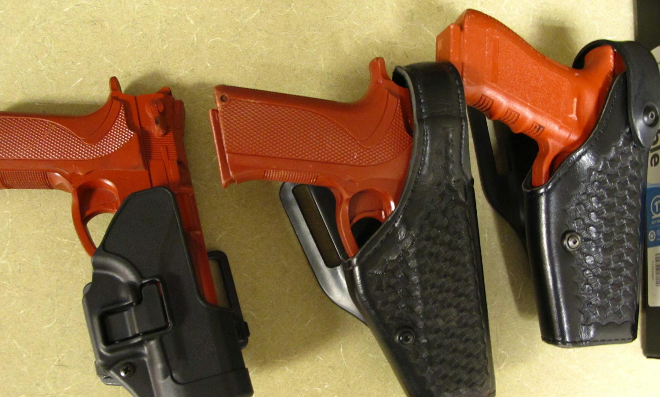 The "red guns" are used to simulate the responsibilities of carrying a firearm. They equal real handguns in shape and weight.