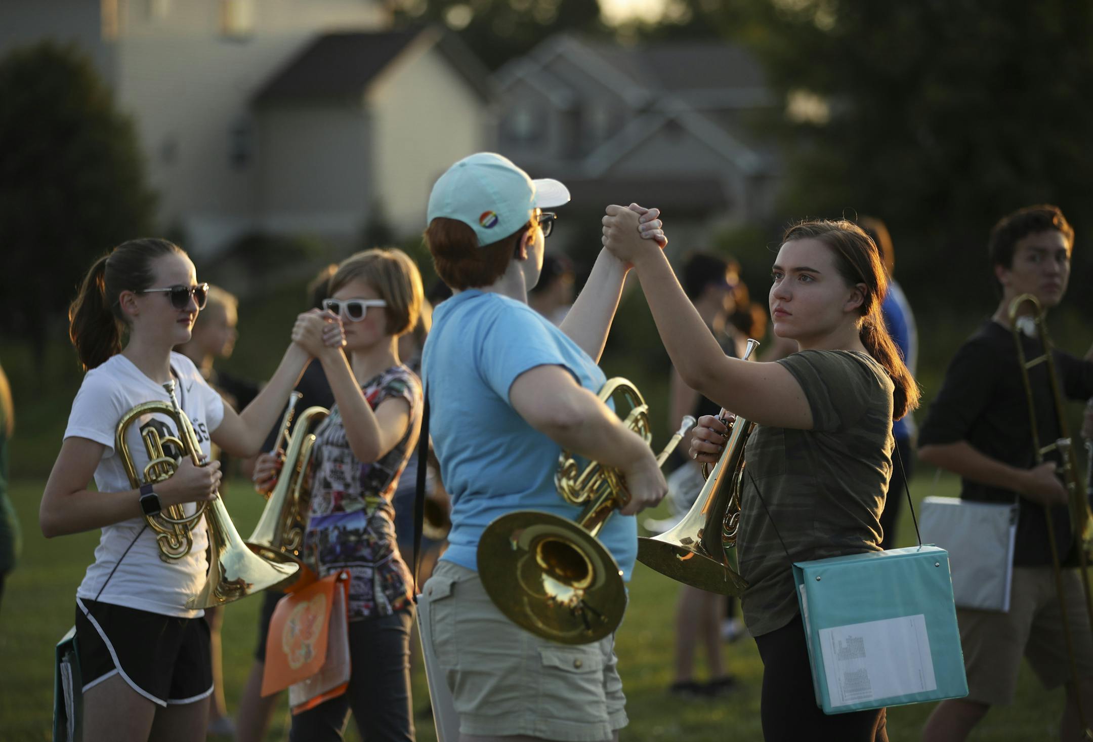 Farmington High School marching band members, including Cas Johnson and Haley Zinnel, right, rehearsed clasping hands at the end of their program, "Dystopia" Thursday night at the school. ] JEFF WHEELER ï jeff.wheeler@startribune.com The Farmington High School marching band has had to revise their halftime program, "Dystopia" slightly after some thought it had political overtones. On Thursday night, the band's rehearsal incorporated the changes while parent volunteers painted new lettering