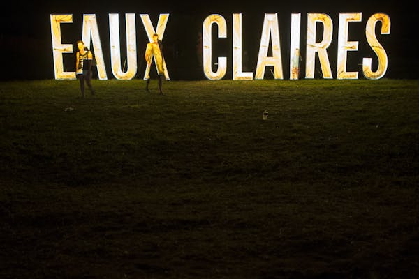 Festivalgoers walked along the illuminated Eaux Claires sign Saturday night during Bon Iver's set.