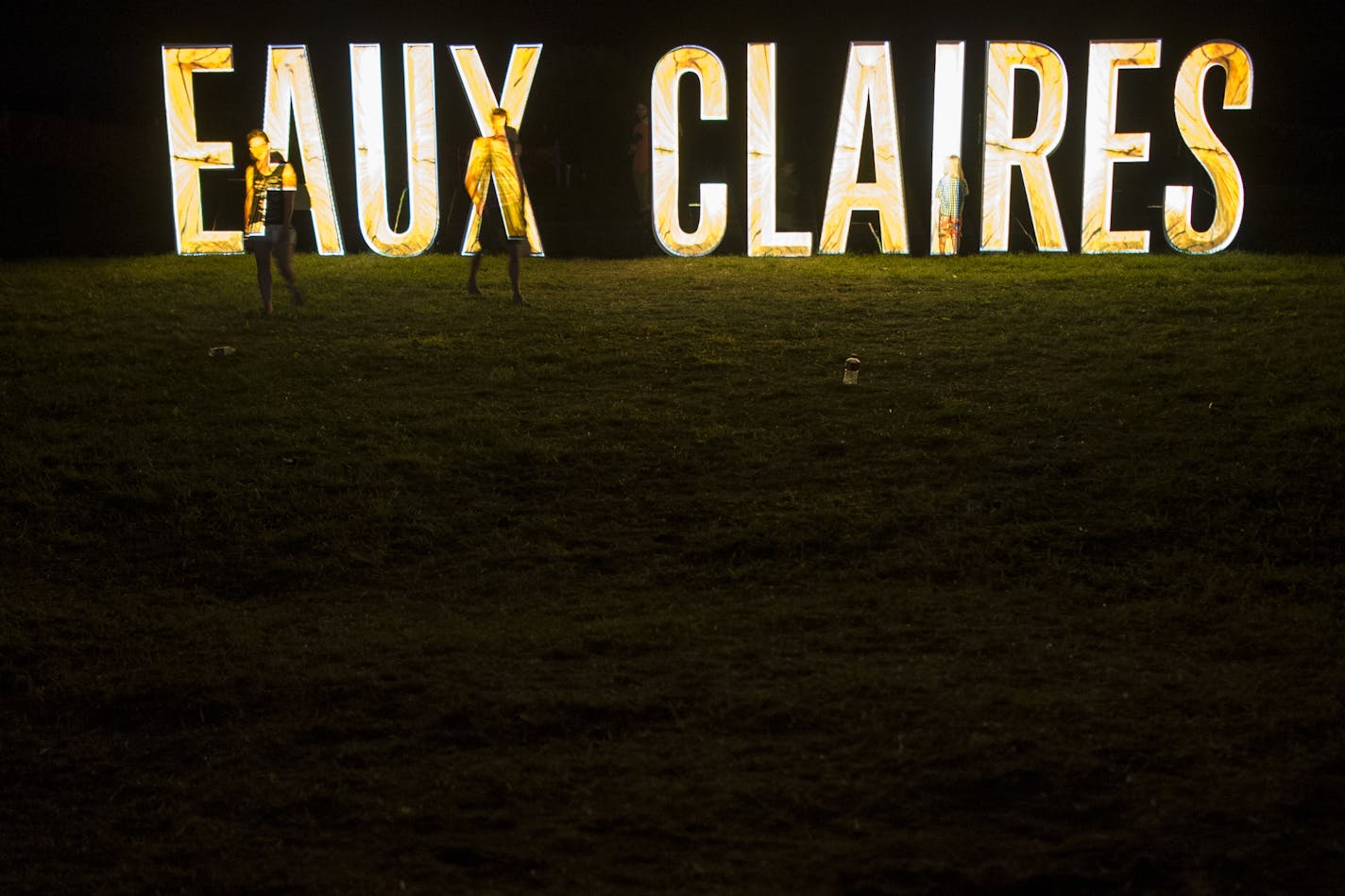 Festivalgoers walked along the illuminated Eaux Claires sign Saturday night during Bon Iver's set.