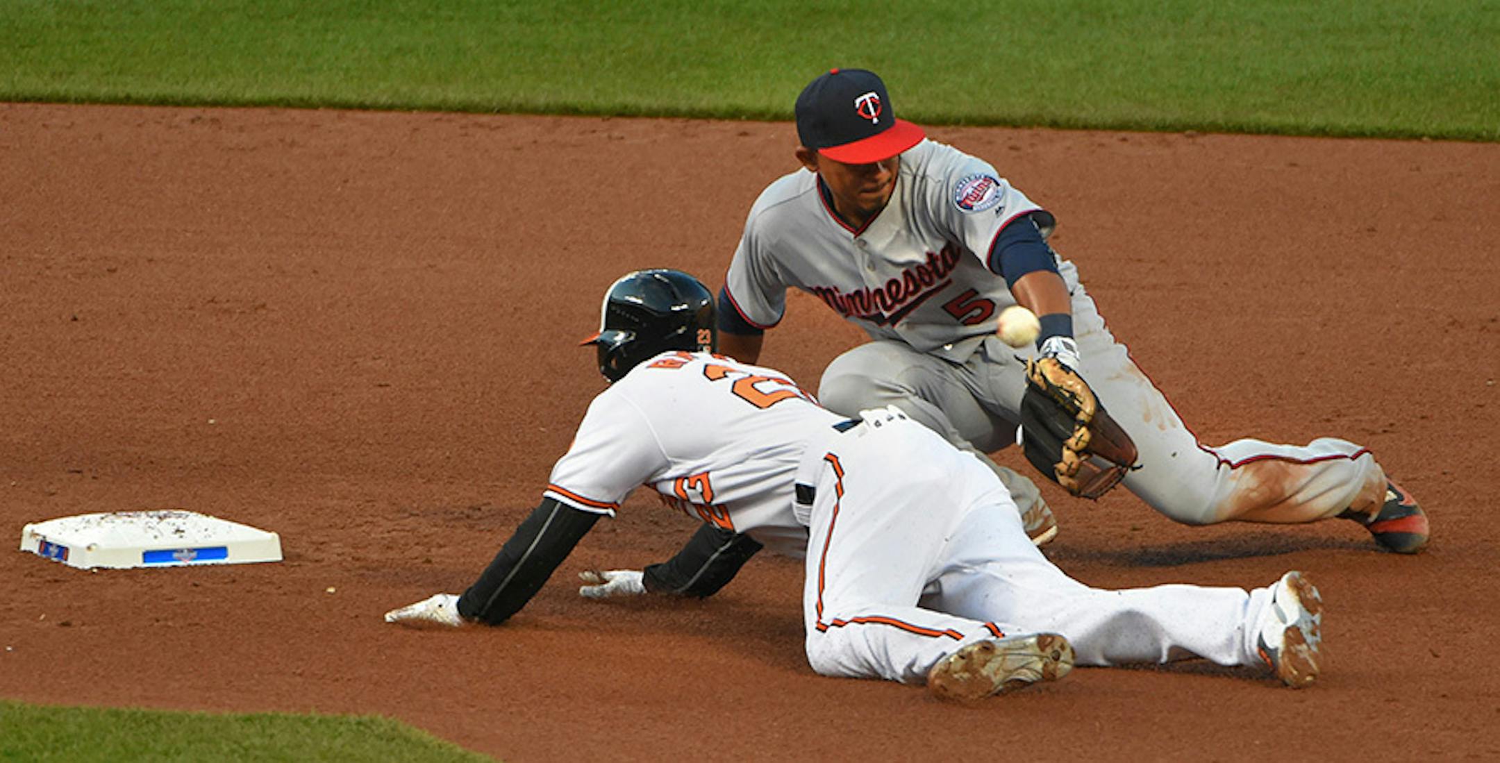 Baltimore Orioles' Joey Rickard slides in with a double as Minnesota Twins shortstop Eduardo Escobar is unable to grab the throw during the fifth inning of Monday's season opener.