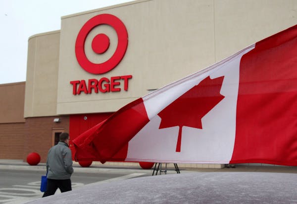In this March 5, 2013 photo, a Canadian flag flies on the car of a customer's car parked in front of a Target store in Guelph, Ontario. On Thursday, J