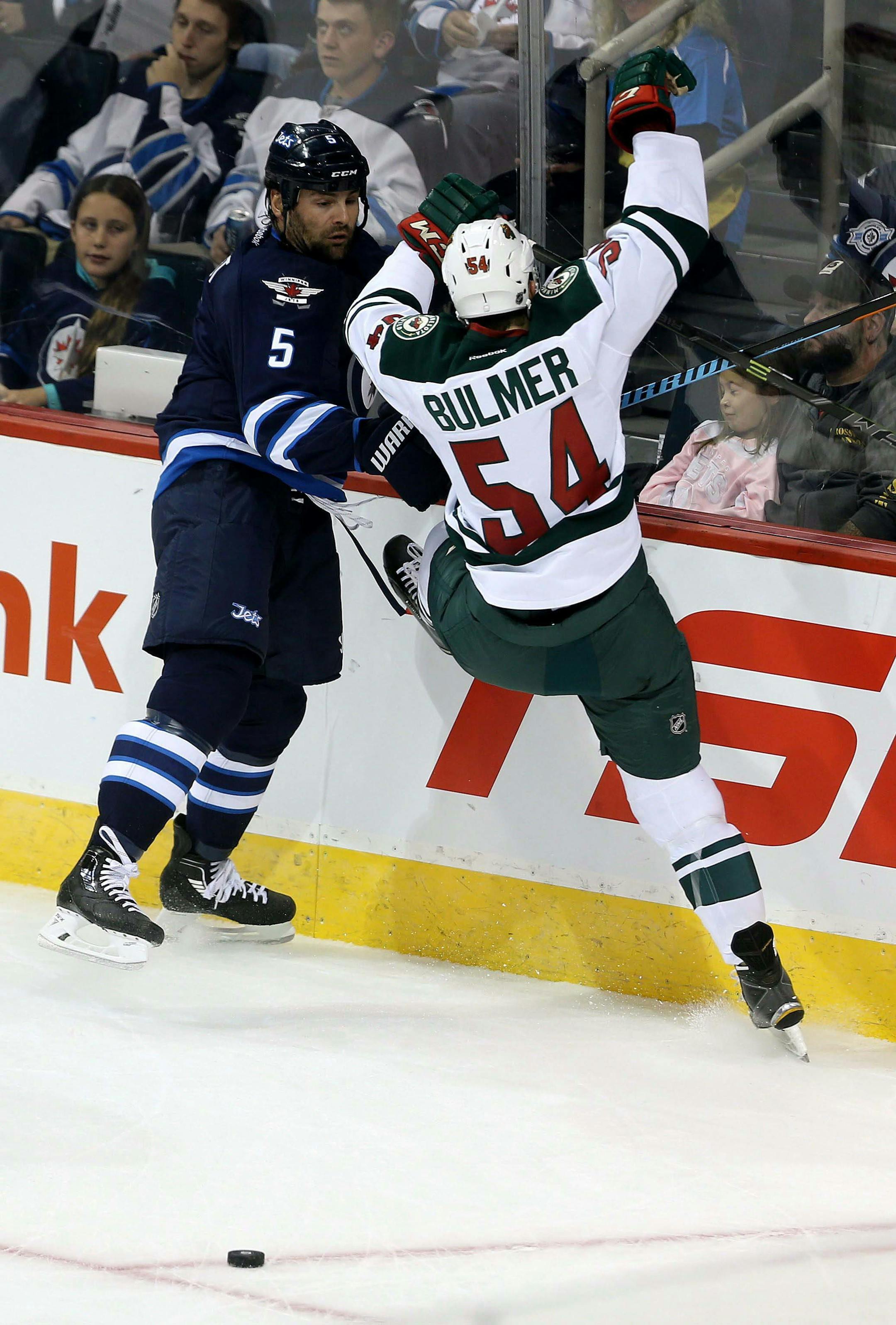 Winnipeg Jets' Mark Stuart, left, hits Minnesota Wild's Brett Bulmer behind the Jets' net during the first period of an NHL preseason hockey game Tuesday, Sept. 22, 2015, in Winnipeg, Manitoba. (Trevor Hagan/The Canadian Press via AP) MANDATORY CREDIT