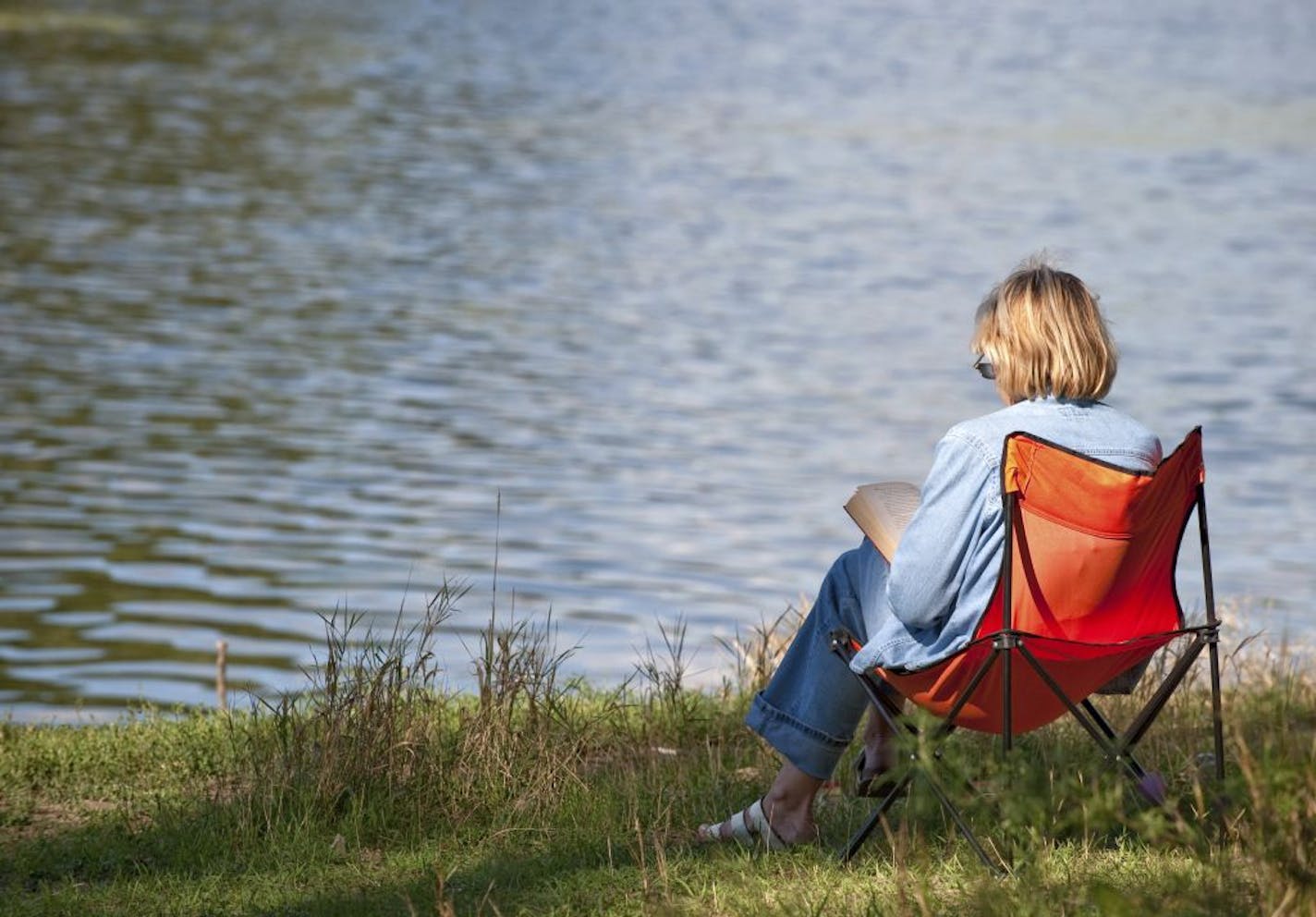 The woman reading the book on coast of lake