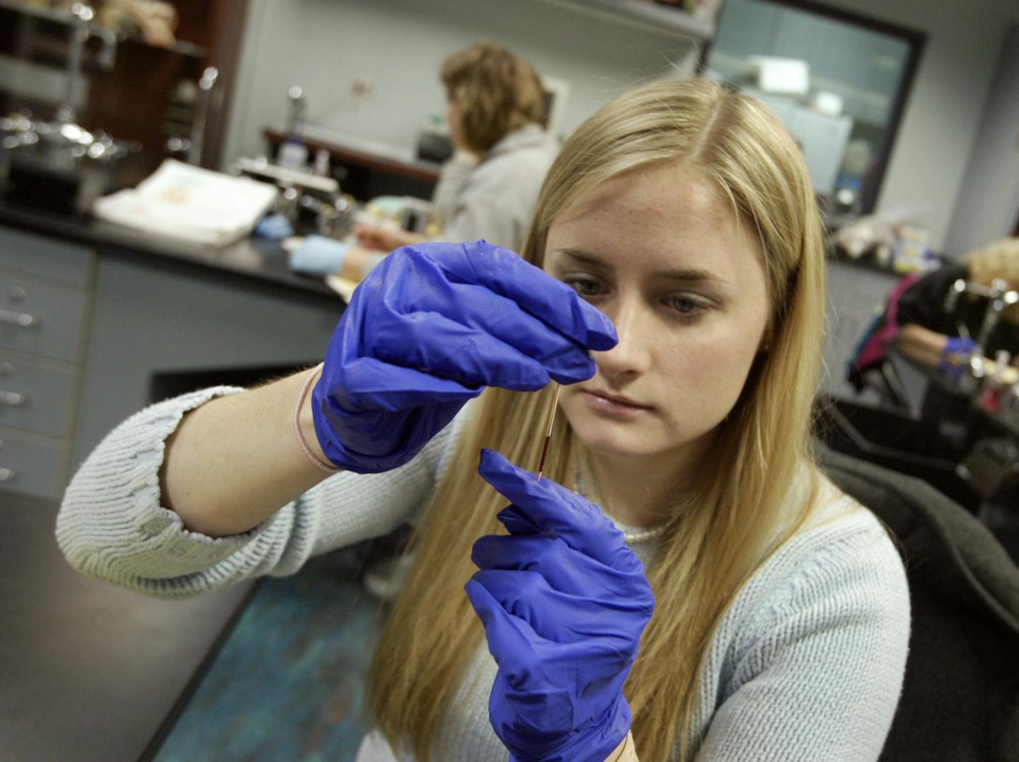 1/28/2005 CAMBRIDGE, MN--Anoka-Ramsey Community College, JaNahn Williams, A Cambridge high school Sr. who has been in this program for two years will graduate with an associates degree in May. Janahn will go to the U of M and have her credits transfer to a dental program there. Here she looks at a vial of blood to determine how many particles of red bllod cells there are.