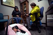 Sara Hernandez, right, reads a bible verse to Geholmin and her one month old baby Ariadnee as they arrive for a weekly visit to Helping Hand Pregnancy