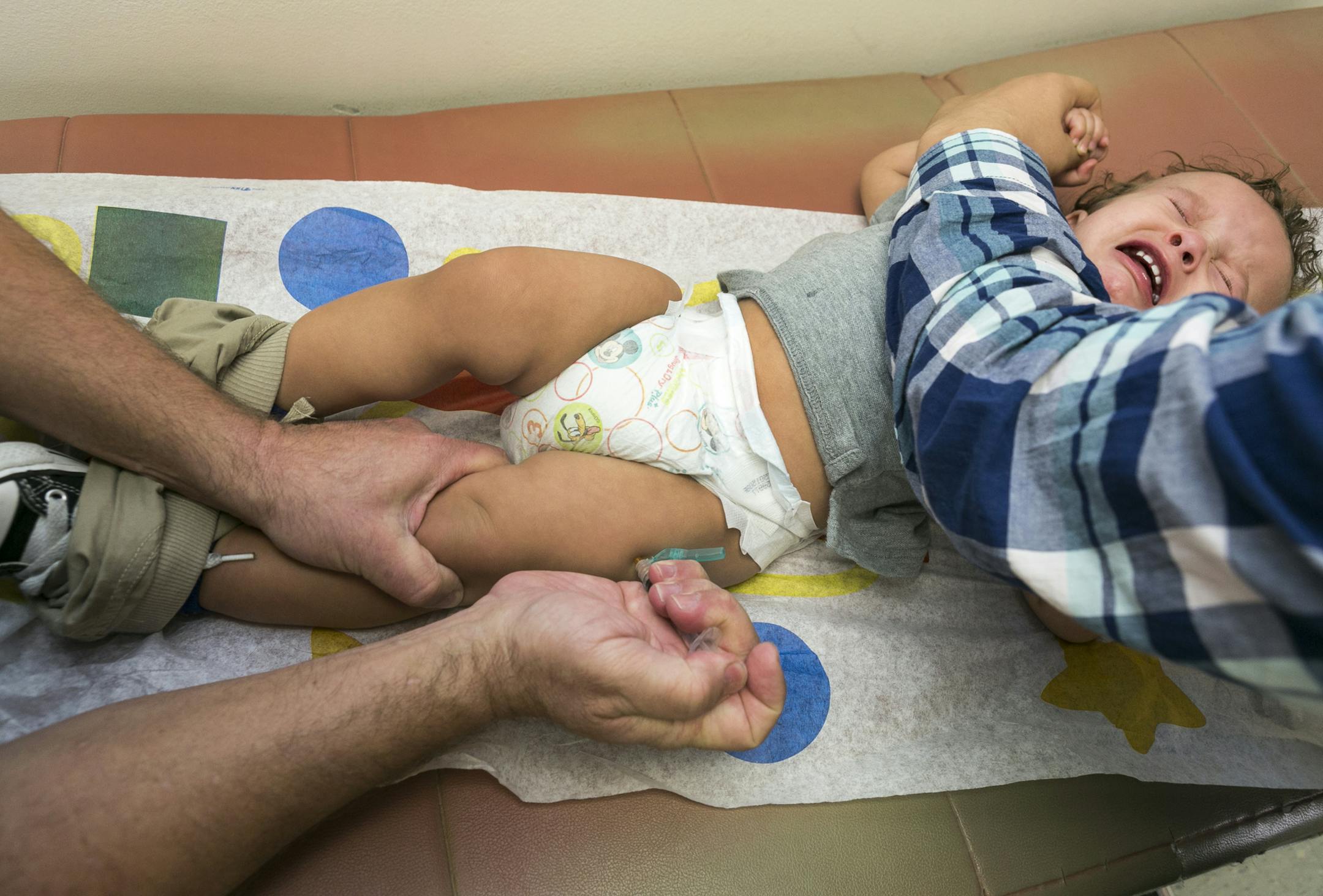 FILE - In this Jan. 29, 2015, file photo, pediatrician Dr. Charles Goodman vaccinates 1 year- old Cameron Fierro with the measles-mumps-rubella vaccine, or MMR vaccine at his practice in Northridge, Calif. The Centers for Disease Control and Prevention reported Tuesday, Feb. 17, 2015, that the number of U.S. measles cases this year has risen to 141, with most of the new illnesses tied to outbreaks at Disneyland in California and an Illinois day care center. (AP Photo/Damian Dovarganes, File)