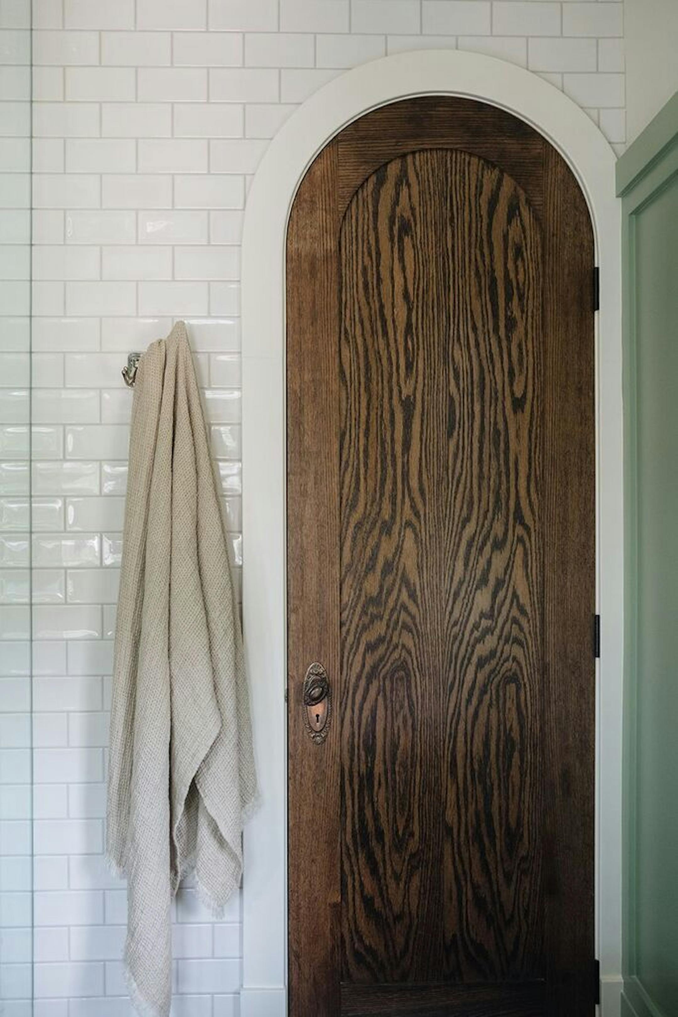 An arched walnut door leads to the linen closet.