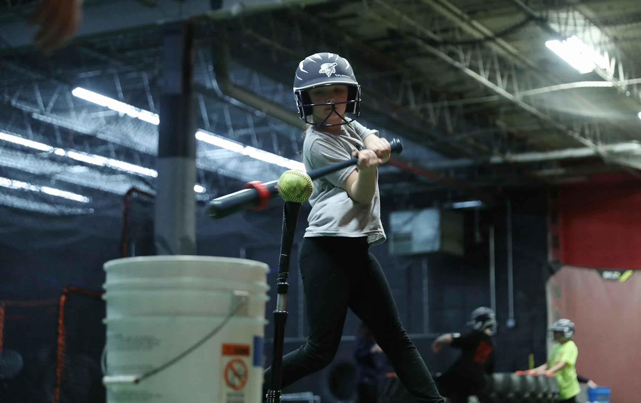 Marie Marcum, 9, works on her swing during practice with her softball team, the Plainfield Twisters, at a workout facility Saturday, March 9, 2019, in Joliet, Ill. Marie wrote a letter to Major League Baseball about an MLB-licensed baseball throwing game at Chuck E. Cheese's entertainment center that made negative audio comments about softball. The sound was deleted from the game by the manufacturer as a result of her letter. (John J. Kim/Chicago Tribune/TNS) ORG XMIT: 1281322 ORG XMIT: MIN19031