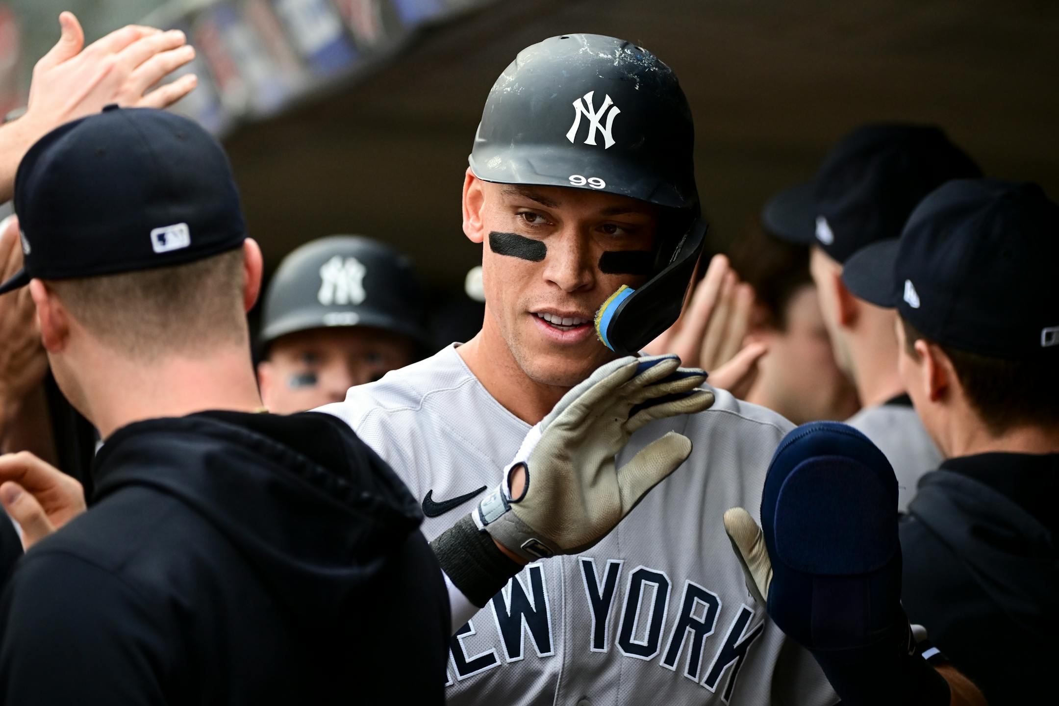 New York Yankees center fielder Aaron Judge (99) high fives teammates after scoring a run against the Minnesota Twins off a sacrifice fly hit by third baseman Josh Donaldson (28) in the top of the first inning.