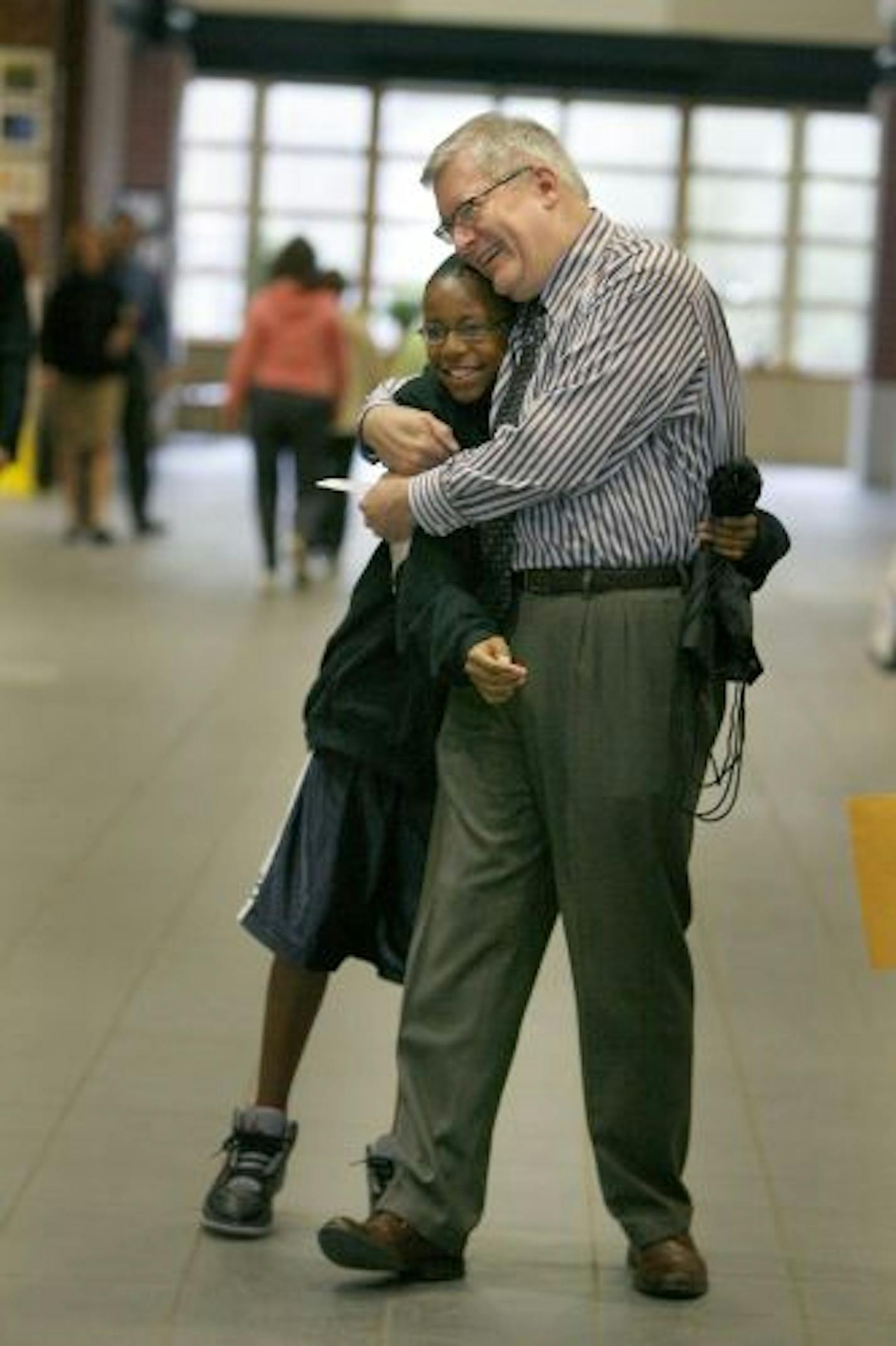 Burroughs Community School Principal Tim Cadotte was greeted with hugs by his students as they made their way to class early Tuesday morning, May 5, 2009, in Minneapolis on Cadotte's first day back to school after a suspension following an altercation with a school board member.