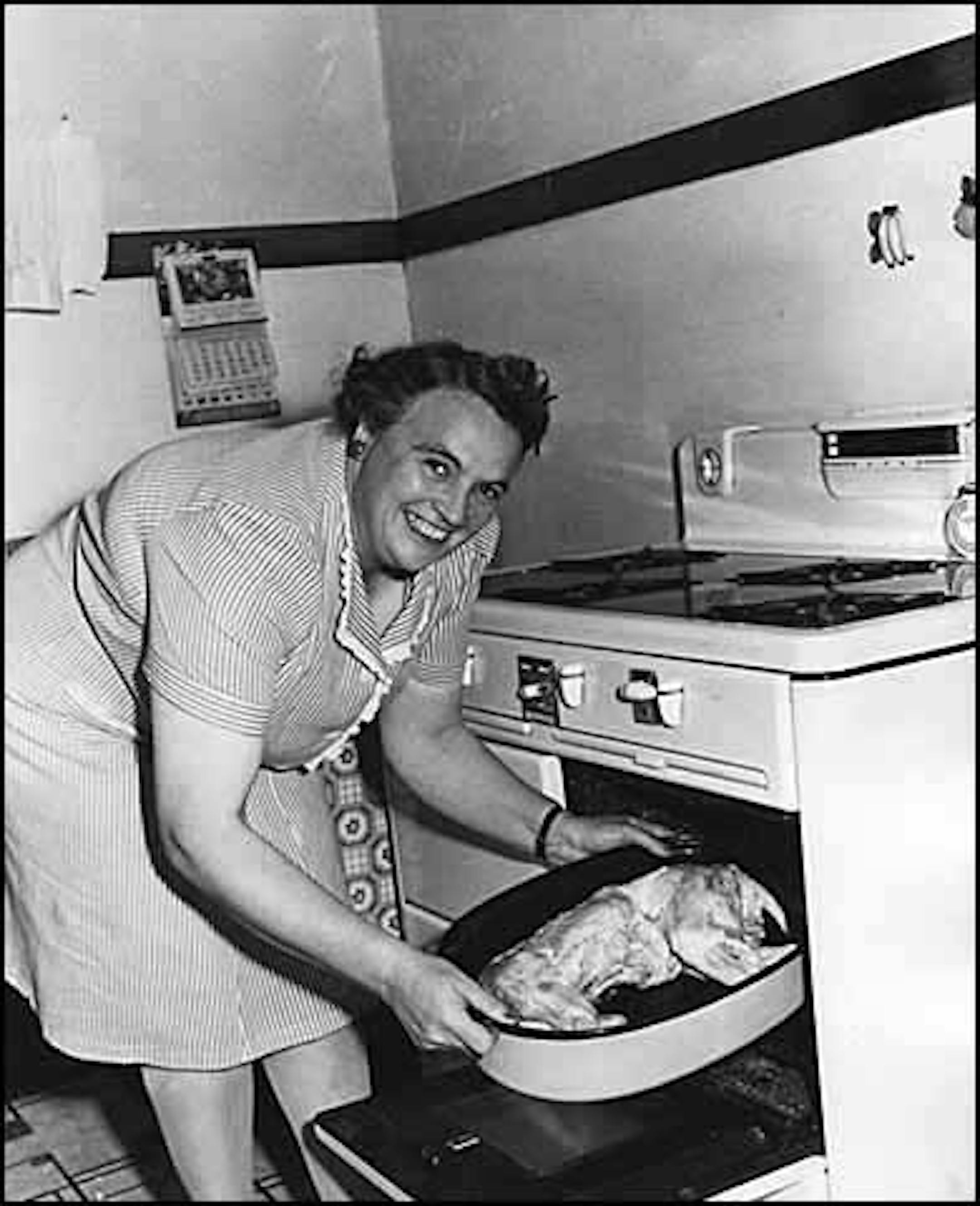 November 1944: Mrs. Charles Vollmer of Cleveland, Minn., puts a 30-pound raccoon prepared for baking into the oven. [for Yesterday's News blog]