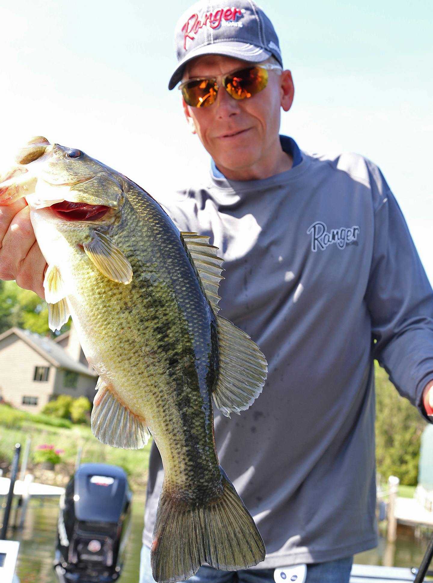 Bob Turgeon held a legally caught bass on Lake Minnetonka, taking advantage of a DNR regulation change that, for the first time, opened bass angling throughout much of the state to catch-and-release fishing when the walleye and northern pike season opened May 9.