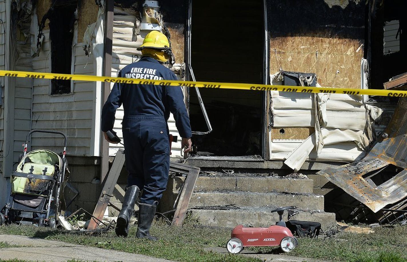 Erie Bureau of Fire Inspector Mark Polanski helps investigate a fatal fire at 1248 West 11th St. in Erie, Pa, on Sunday, Aug. 11, 2019. Authorities say an early morning fire in northwestern Pennsylvania claimed the lives of multiple children and sent another person to the hospital.