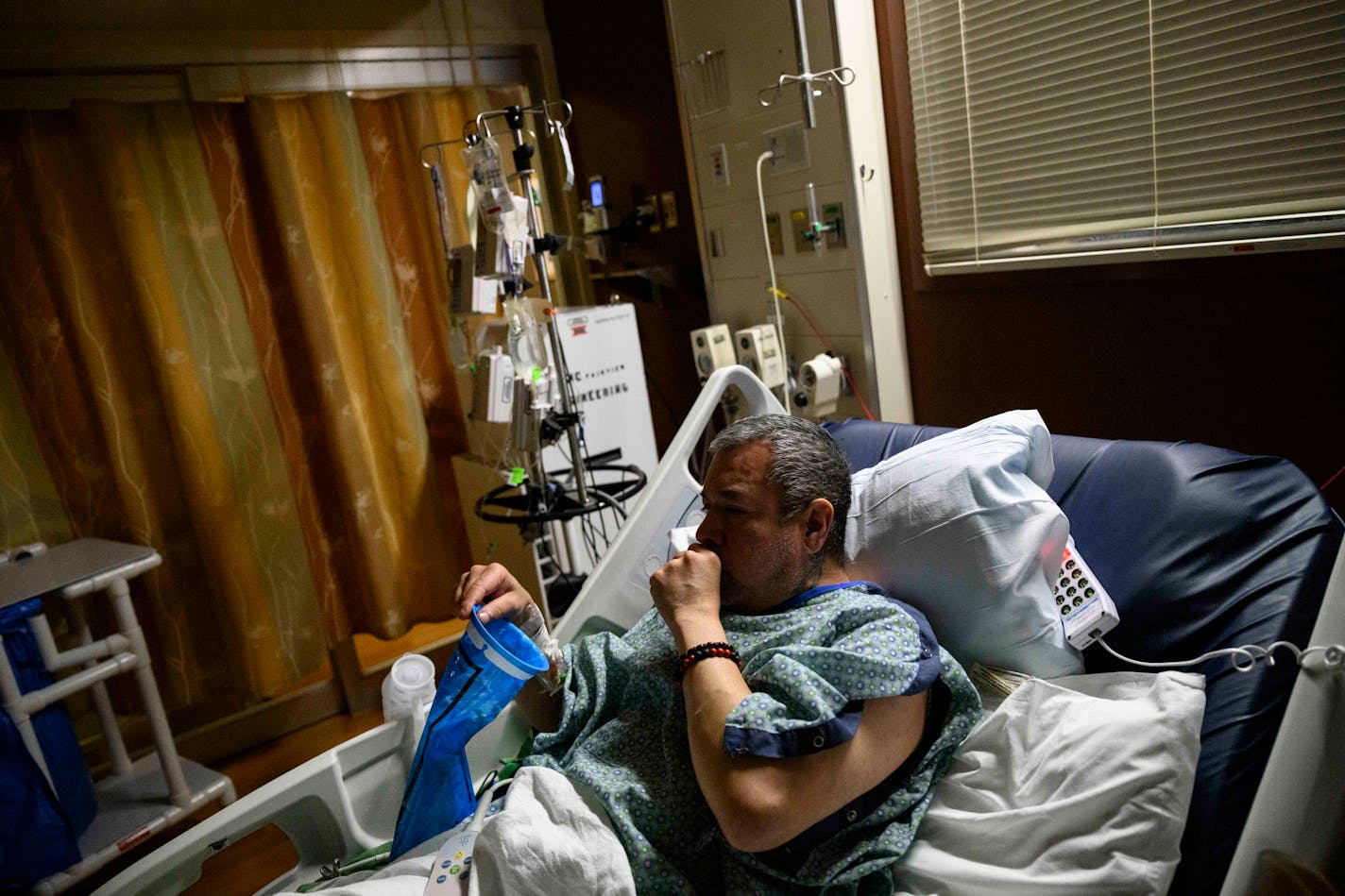 Jesse Rouse, 47, of Minneapolis, coughs deeply as he lays sick with COVID-19 Friday, Nov. 12, 2021 in the 4C Wing at M Health Fairview University of Minnesota Medical Center in Minneapolis, Minn. Rouse says this is the second time he's contracted COVID-19, both times serious. Rouse previously had a double lung transplant and is unvaccinated. ] AARON LAVINSKY • aaron.lavinsky@startribune.com