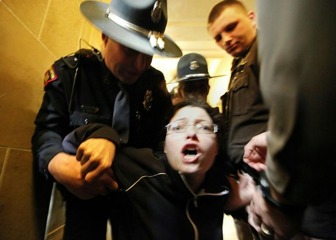 A demonstrator was unwillingly escorted out of the Assembly lobby at the Wisconsin Capitol Thursday.