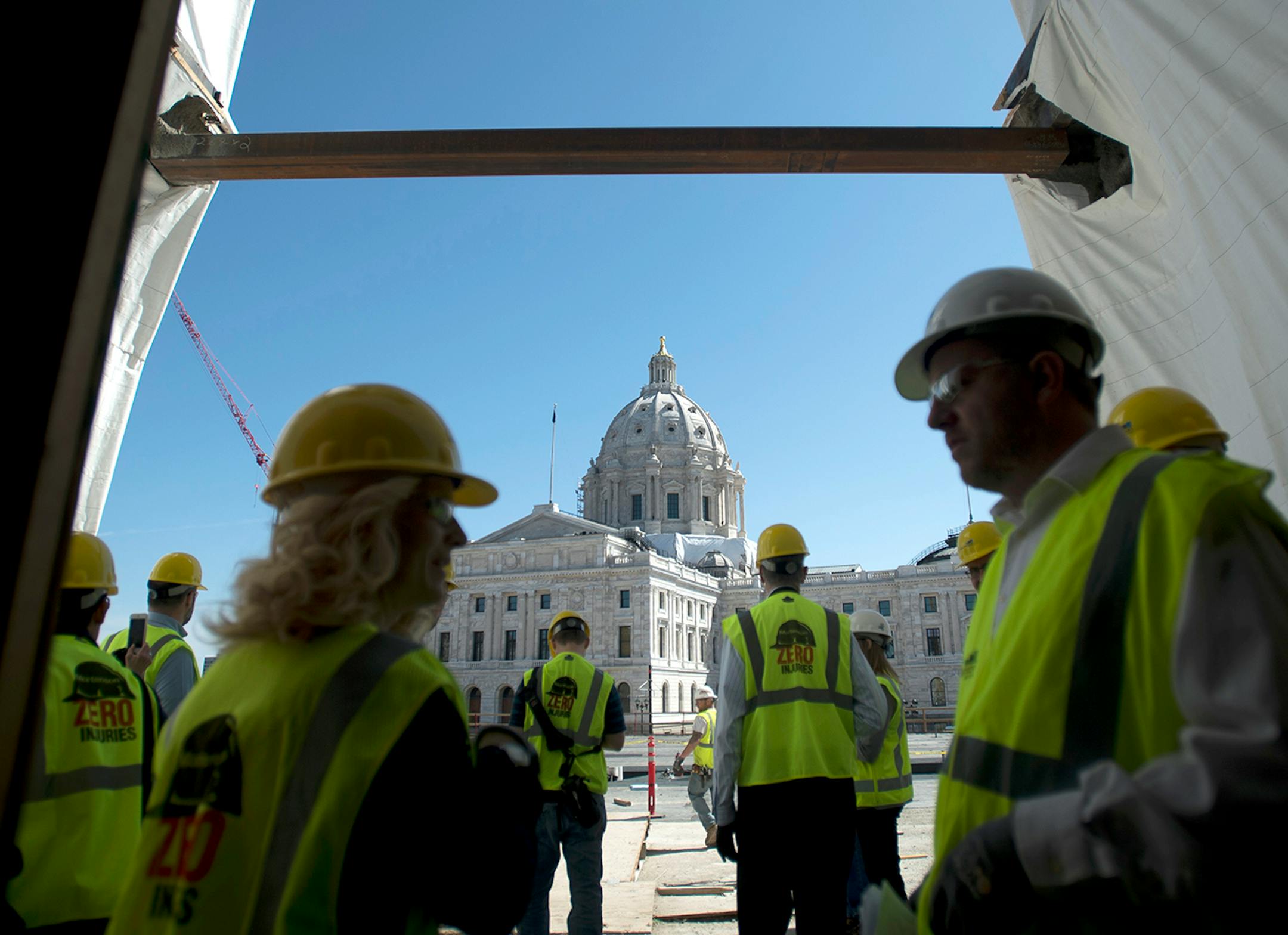 Greg Huber, right, the senior project manager with Mortensen's Construction overseeing the Senate Office Building project, speaks to a member of the media as other participants of the tour make their way out onto the new green plaza area on Tuesday afternoon.