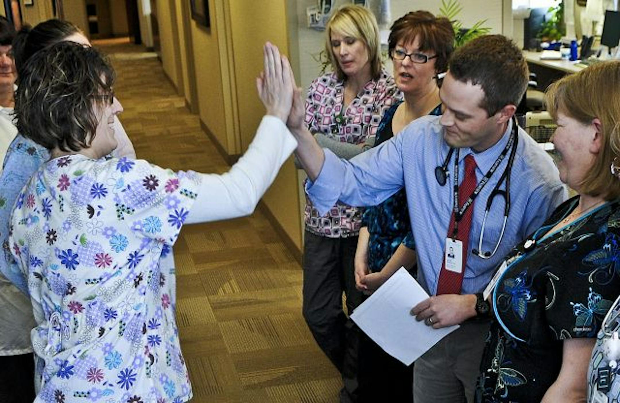 At the Fairview Rosemount Clinic, Dr. Jacob Wasson led the treatment team meeting as the huddle-master. Wasson and R.N. Shelley Kuhlmann high-fived after the meeting.
