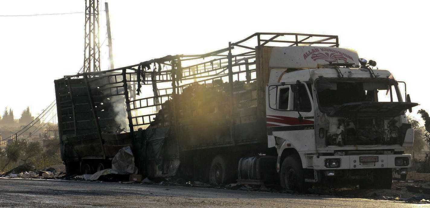 This image provided by the Syrian anti-government group Aleppo 24 news, shows a vest of the Syrian Arab Red Crescent hanging on a damaged vehicle, in Aleppo, Syria, Tuesday, Sept. 20, 2016. A U.N. humanitarian aid convoy in Syria was hit by airstrikes Monday as the Syrian military declared that a U.S.-Russian brokered cease-fire had failed, and U.N. officials reported many dead and seriously wounded. (Aleppo 24 news via AP) ORG XMIT: HAS104