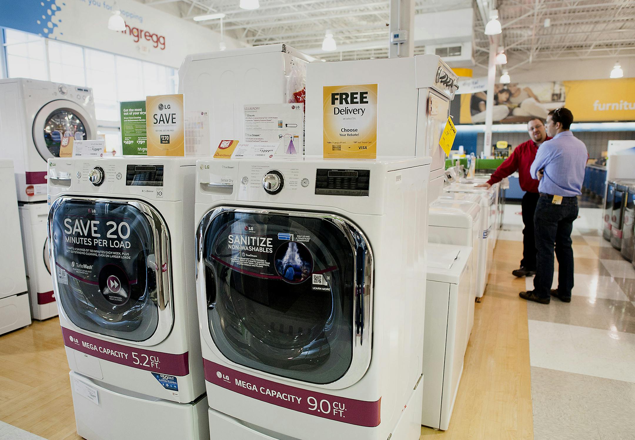 Washer and dryer sets are displayed for sale as an employee assists a customer at an H.H. Gregg Inc. store in Reynoldsburg, Ohio, U.S., on Sunday, May 18, 2014. The U.S. Census Bureau is scheduled to release durable goods figures on May 27. Photographer: Ty Wright/Bloomberg ORG XMIT: 493890759