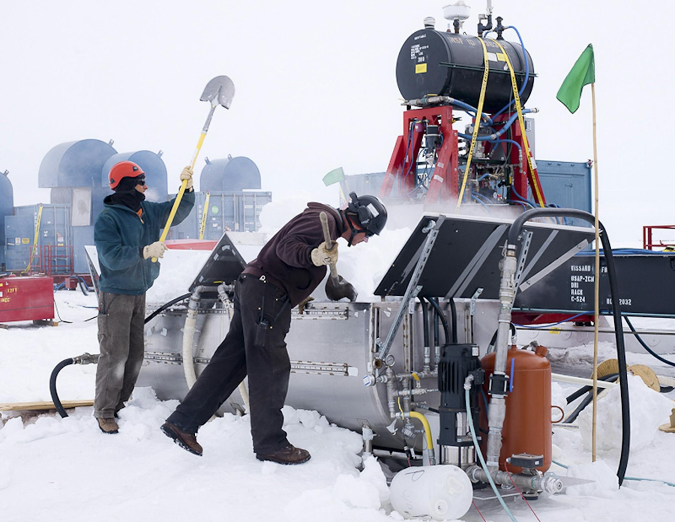 In an undated handout photo, Daren Blythe and Dar Gibson shovel snow into a melter feeding a hot water drill to be used to penetrate half a mile of ice above Lake Whillans in Antarctica. The $10-million American expedition is drilling the hole to look for signs of microbial life in the buried lake. (J.T. Thomas via The New York Times) -- NO SALES; FOR EDITORIAL USE ONLY WITH STORY SLUGGED SCI UNDER ICE LIFE BY JAMES GORMAN. ALL OTHER USE PROHIBITED. --