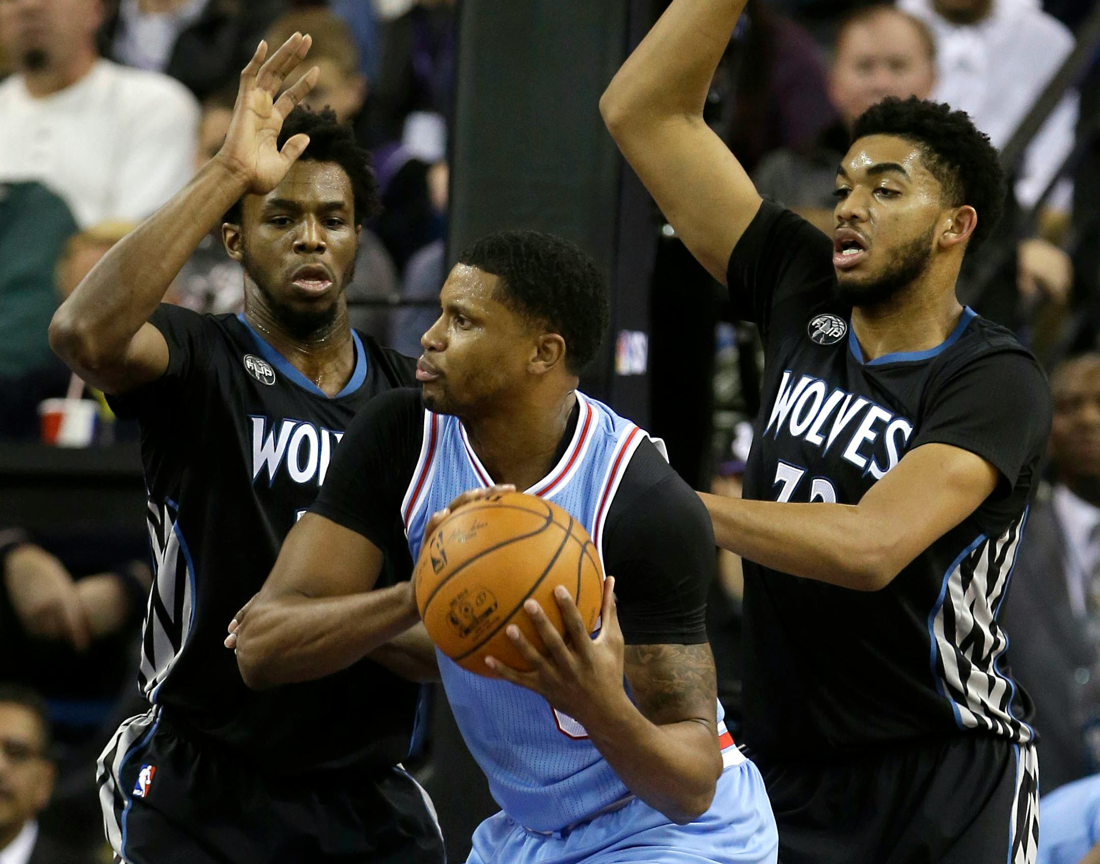 Sacramento forward Rudy Gay, center, is double-teamed by Minnesota's Andrew Wiggins, left, and Karl-Anthony Towns during the first quarter of an NBA basketball game in Sacramento, Calif., Friday, Nov. 27, 2015.(AP Photo/Rich Pedroncelli)