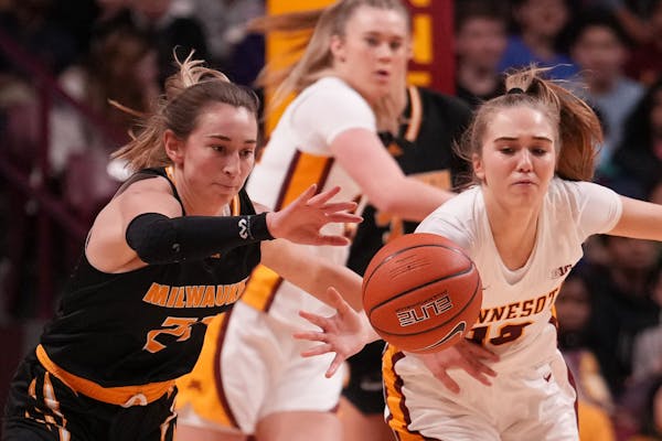 Milwaukee Panthers guard Angie Cera (22) and Minnesota Gophers guard Mara Braun (10) race for a loose ball in the first half.