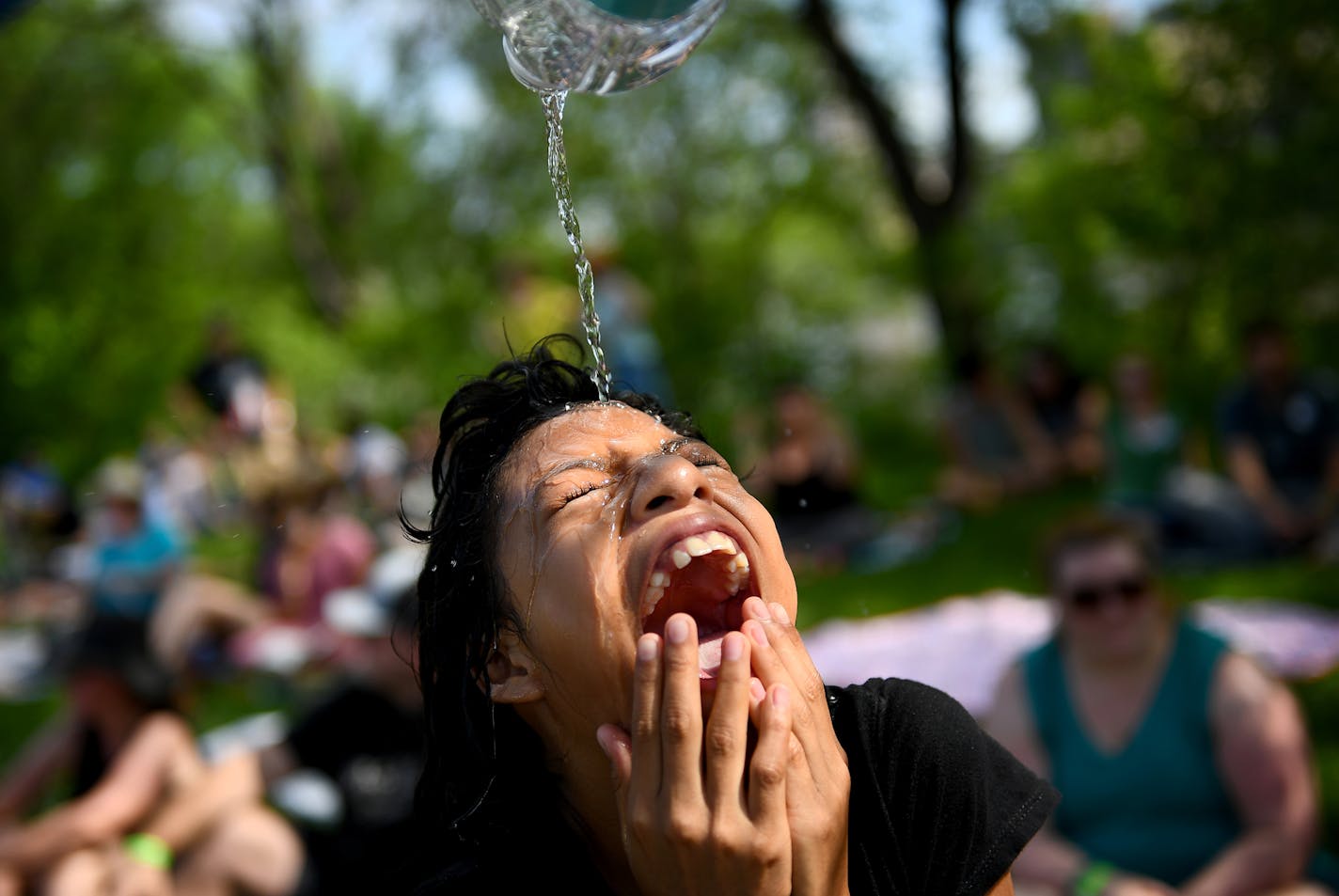 Edward Schroering, not pictured, of Tampa Bay, dumped a bottle of water on the head of his daughter Marisa, 11, while relaxing near some shade at Boom Island Park Saturday. Water was in high demand, with lines hundreds of feet long at hydration stations. ] (AARON LAVINSKY/STAR TRIBUNE) aaron.lavinsky@startribune.com Rock The Garden was held at Boom Island Park on Saturday, June 18, 2016 in Minneapolis, Minn. Acts included Grrrl Prty, Nathaniel Rateliff & Night Sweats, Hippo Campus, Chance the Ra