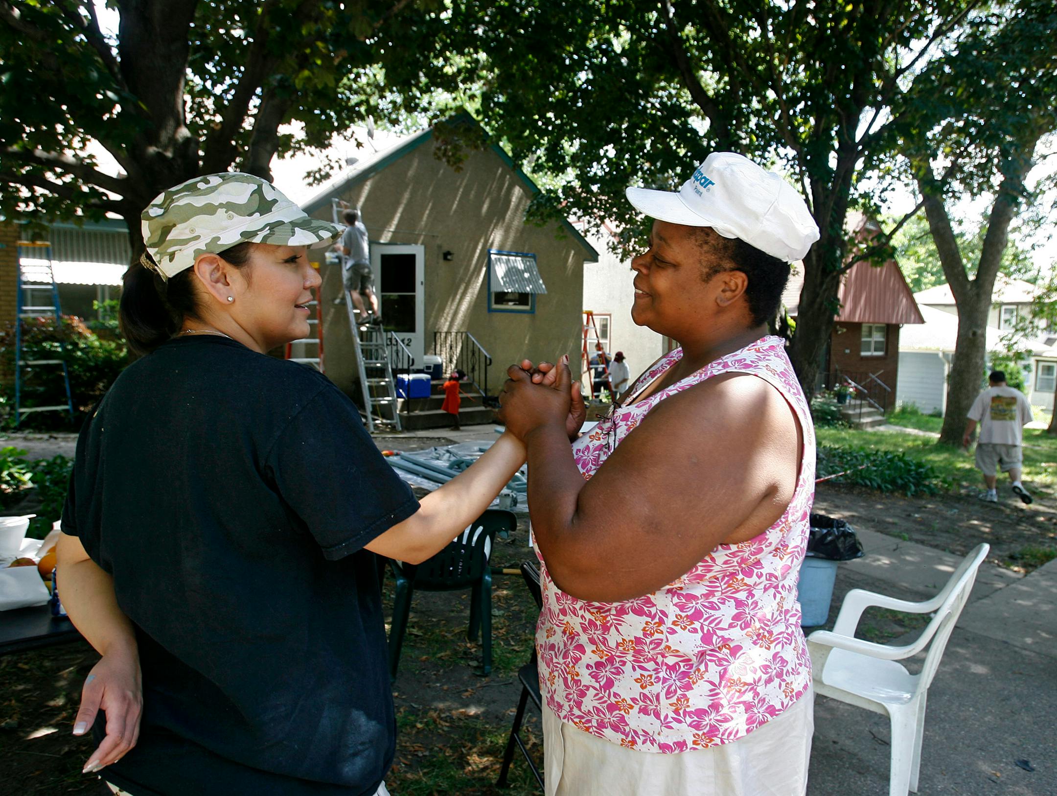 Homeowner Veronica Smith, right, gave a heart-felt thanks Friday to volunteer Sky Matte, a Cuningham Group employee who flew in from Las Vegas to team up with other Cuningham employees to help Habitat for Humanity renovate 10 homes in north Minneapolis. More than 200 Cuningham Group employees pitched in.