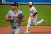 The Orioles' Cedric Mullins rounds the bases after hitting a two-run, walk-off home run while Twins second baseman Edouard Julien jogs off the field W