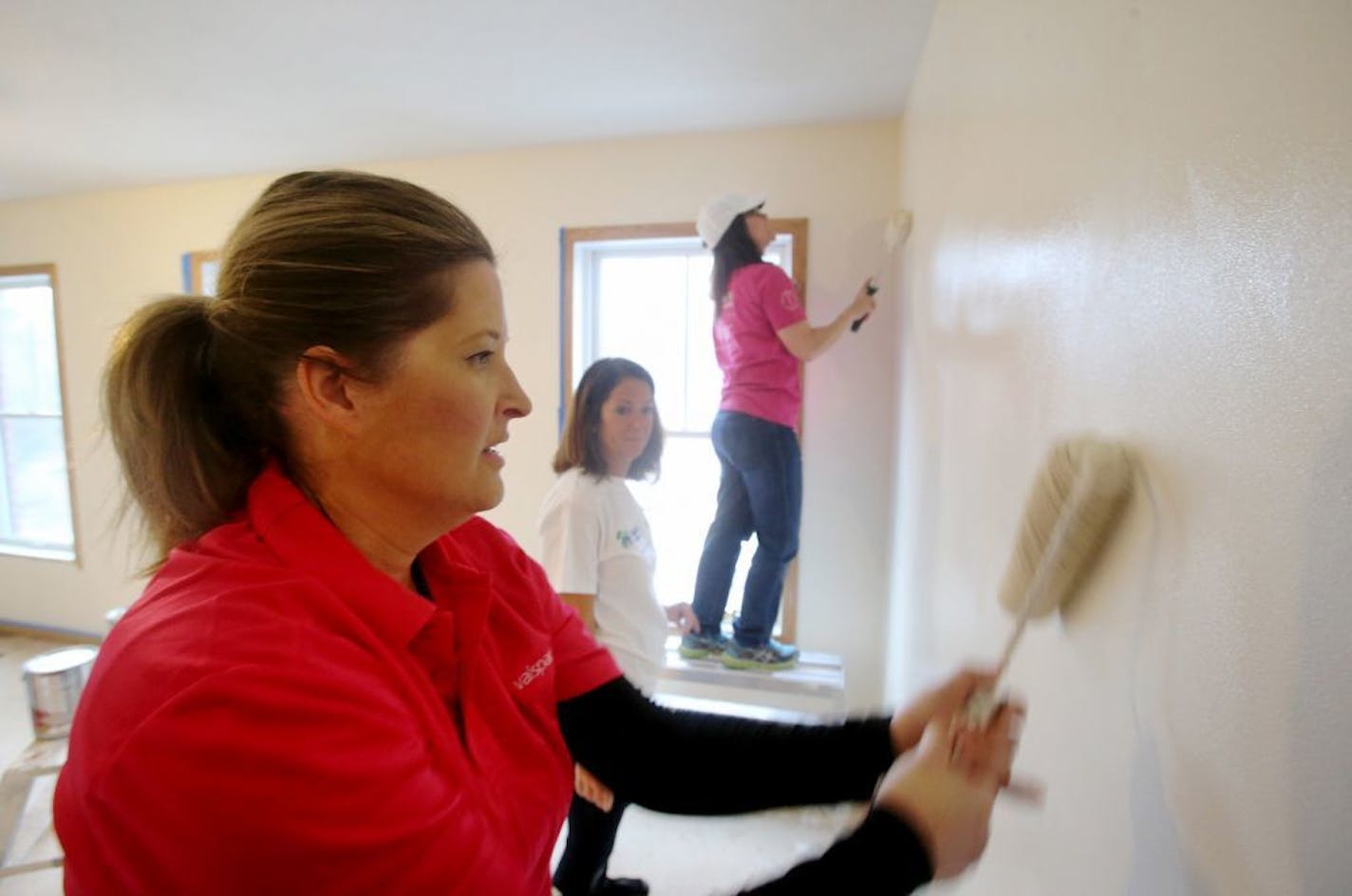 Valspar employees volunteered to paint rooms inside a Habitat for Humanity house Thursday, March 19, 2015, in Minneapolis, MN. Here, Tammy Meyer, executive assistant, left to right, Sue Becker, lead recruiter and Kim Welch, corporate communications and Sue Becker, lead recrutier, painted.