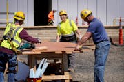 Apprentice carpenter Breanna Dornsbach, second from right, who works for Knutson Construction, laughs while getting some good nature teasing from co-w