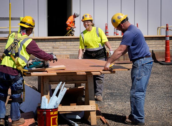 Apprentice carpenter Breanna Dornsbach, second from right, who works for Knutson Construction, laughs while getting some good nature teasing from co-w