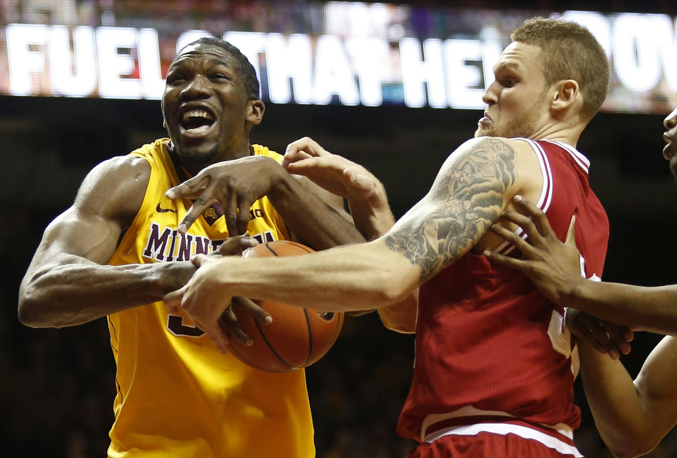 Minnesota's Trevor Mbakwe, left, battles over a rebound with Indiana's Derek Elston