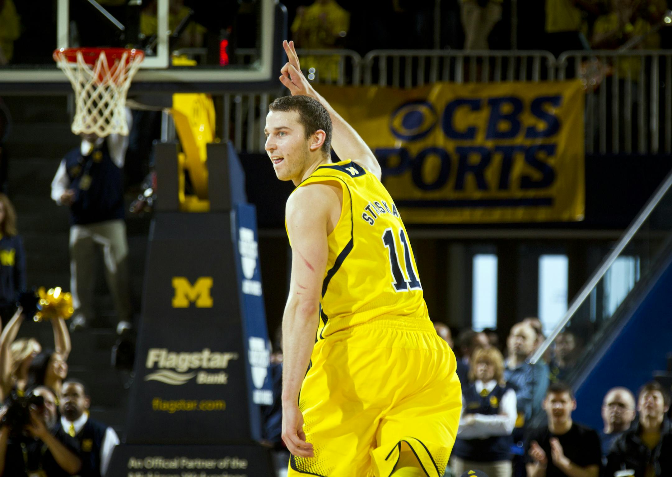 Michigan guard Nik Stauskas (11) reacts by holding up three fingers to celebrate his 3-pointer in the second half of an NCAA college basketball game against Michigan State at Crisler Center, Sunday, Feb. 23, 2014, in Ann Arbor, Mich.. Michigan won 79-70. (AP Photo/Tony Ding) ORG XMIT: AAS114