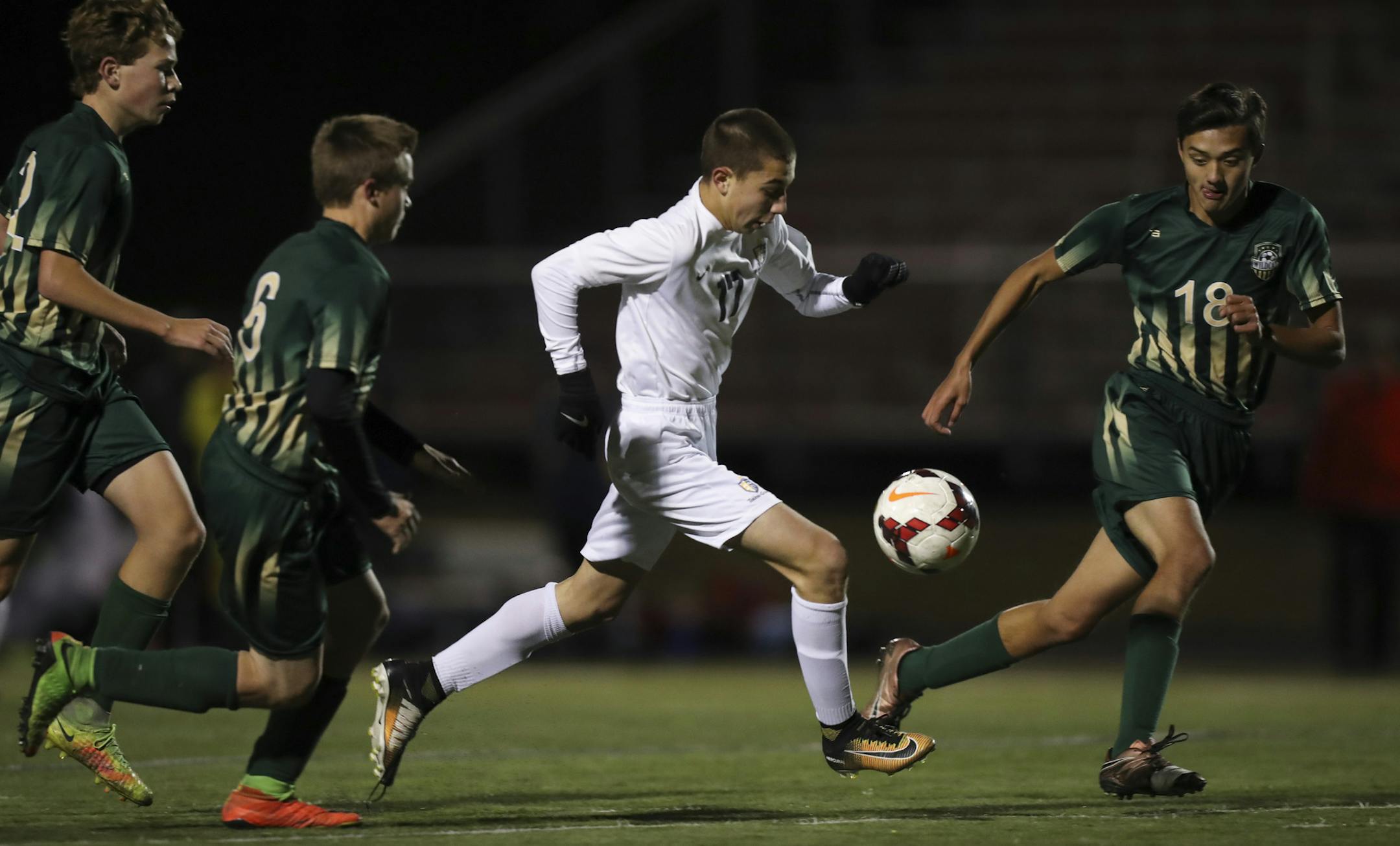 Totino-Grace's Collin Matzoll took the ball upfield in the second half while defended by Chisago Lakes, Lindstrom's Andrew Johnsen, Toby Stec, and Sam Pullis, from left. ] JEFF WHEELER ï jeff.wheeler@startribune.com Totino-Grace shut out Chisago Lakes, Lindstrom 4-0 in their boy's Class 1A Soccer State Tournament quarterfinal game Tuesday night, October 24, 2017 at Farmington High School.