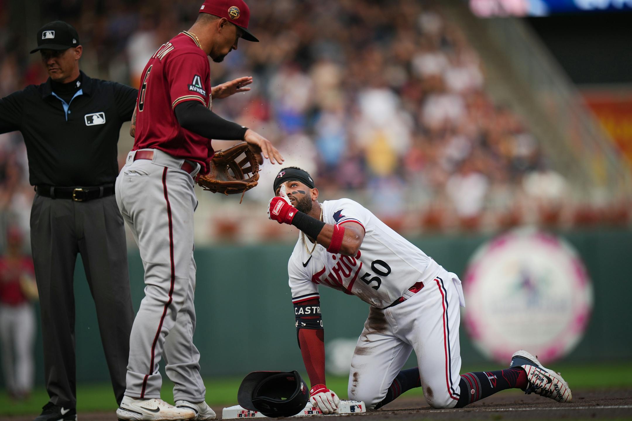 Minnesota Twins left fielder Willi Castro (50) checks in with Arizona Diamondbacks third baseman Jace Peterson (6) after hitting a triple with a run batted in during the second inning.