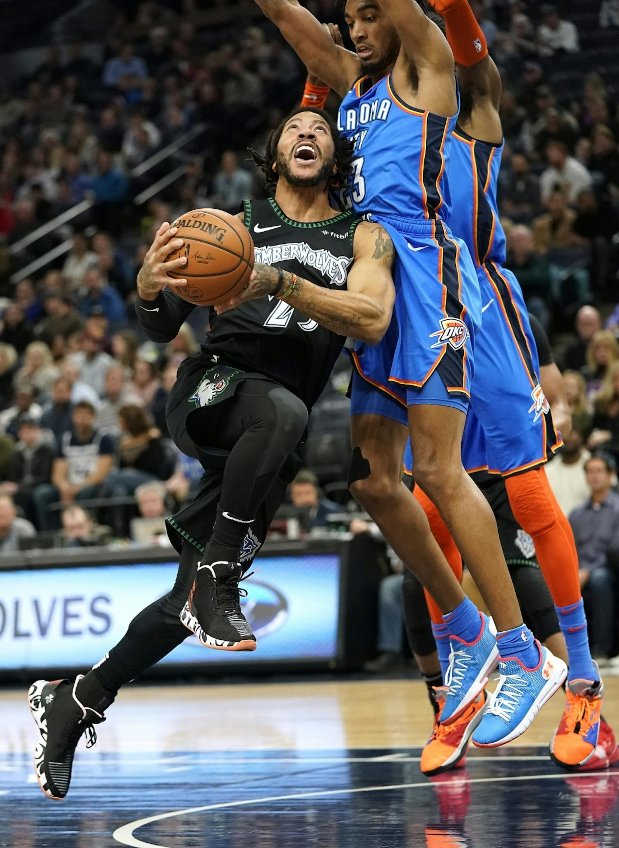 Minnesota Timberwolves guard Derrick Rose (25) comes up against Oklahoma City Thunder guard Terrance Ferguson (23) while trying to shoot during the first half.