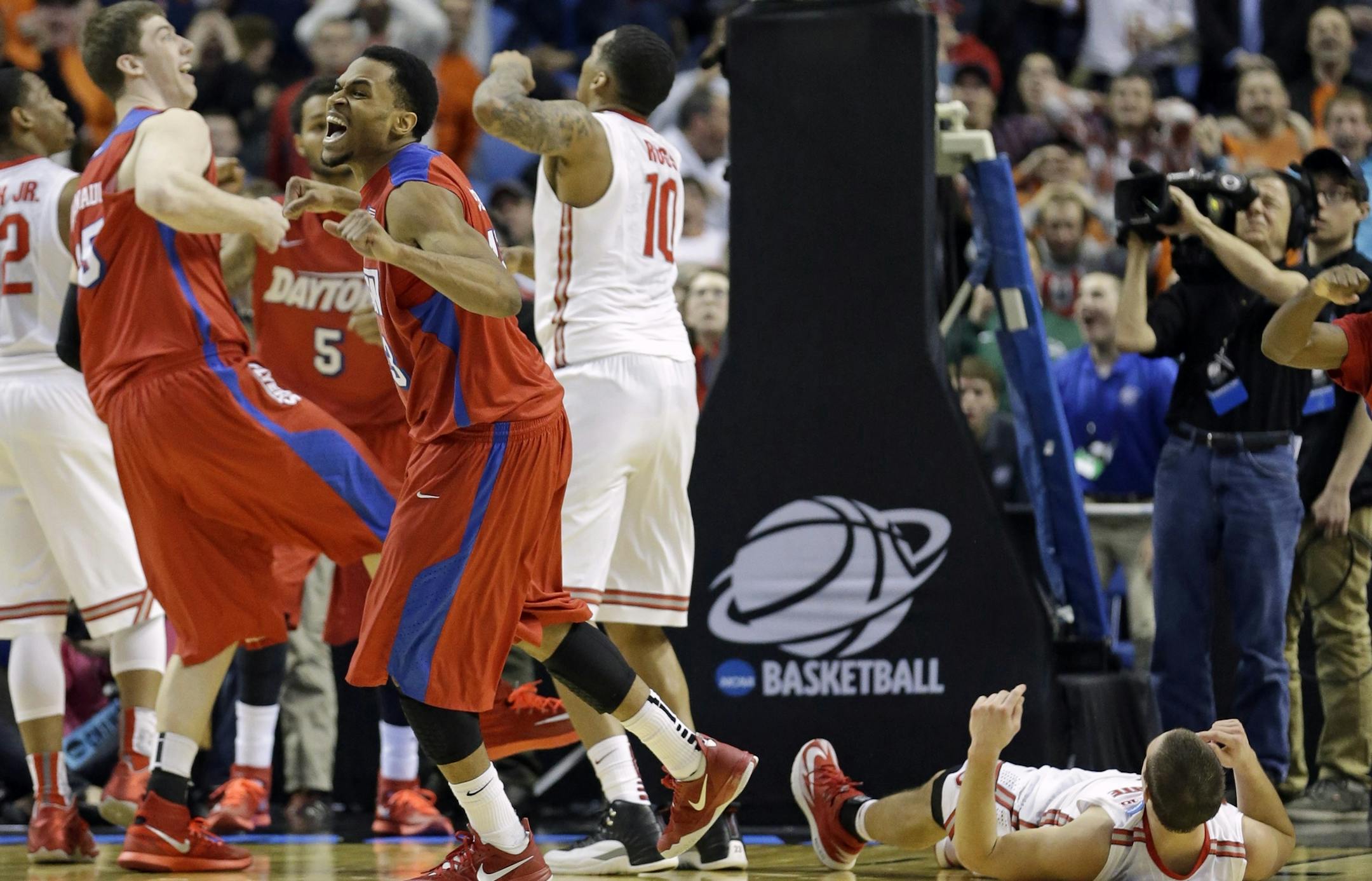 Dayton's Vee Sanford, fourth from left, and Matt Kavanaugh, second from left, react after Ohio State's Aaron Craft, right, missed the final shot of the second half of a second-round game in the NCAA college basketball tournament in Buffalo, N.Y., Thursday, March 20, 2014. Dayton won 60-59. (AP Photo/Frank Franklin II)