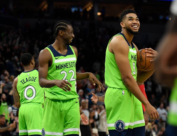 The Minnesota Timberwolves' Karl-Anthony Towns, right, and Andrew Wiggins (22) are all smiles following a 115-109 victory against the Toronto Raptors 