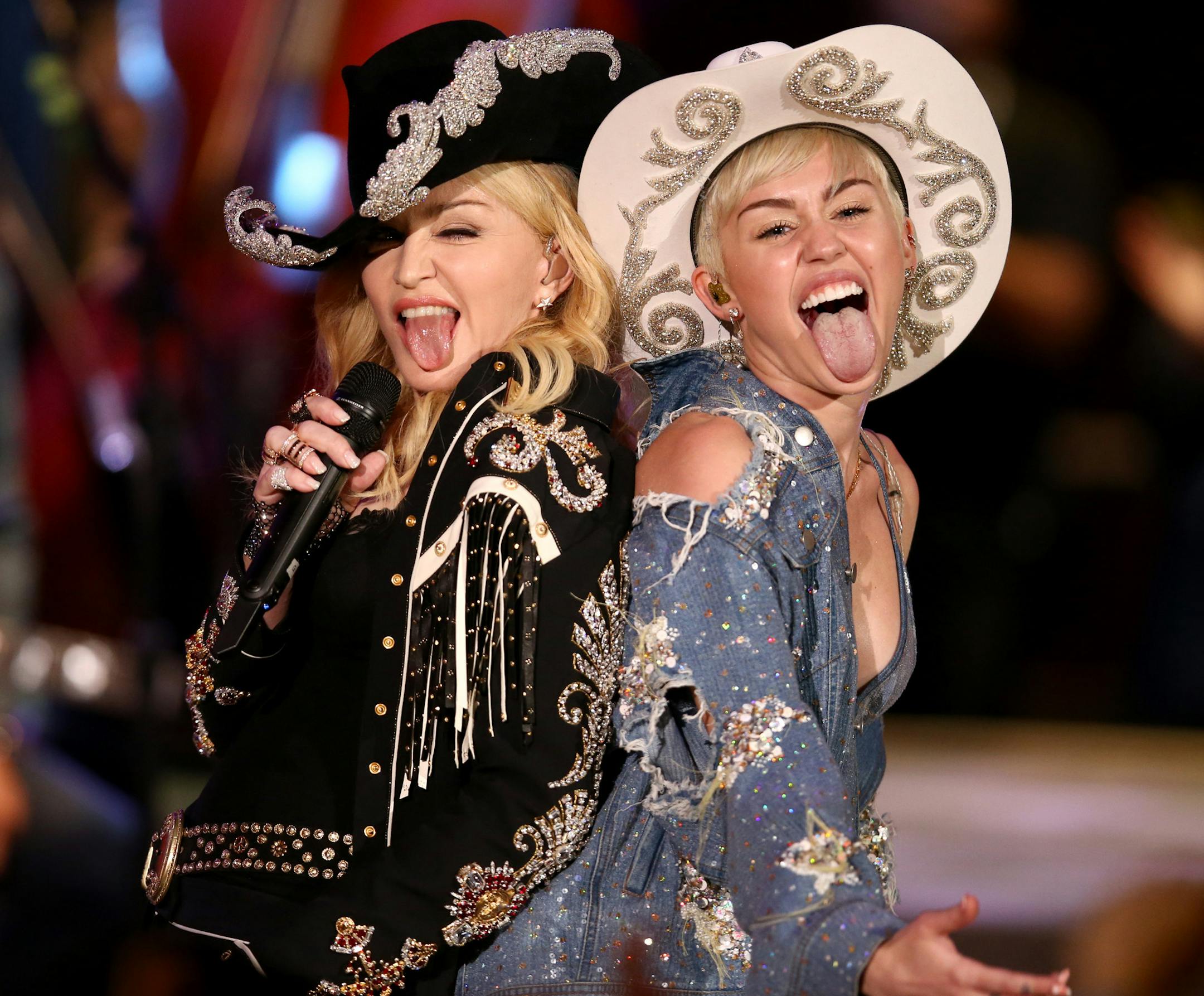 In this Tuesday, Jan. 28, 2014 photo provided by MTV, Miley Cyrus performs with Madonna during the taping of "Miley Cyrus: MTV Unplugged," in the Hollywood section of Los Angeles. The 21-year-old pop star and the 55-year-old Queen of Pop grinded and grabbed each other as they performed Cyrus' hit "We Can't Stop" and Madonna's 2000 track "Don't Tell Me." The MTV special that closes with the duet is set to air Wednesday. (AP Photo/MTV, Chris Polk) ORG XMIT: NY107