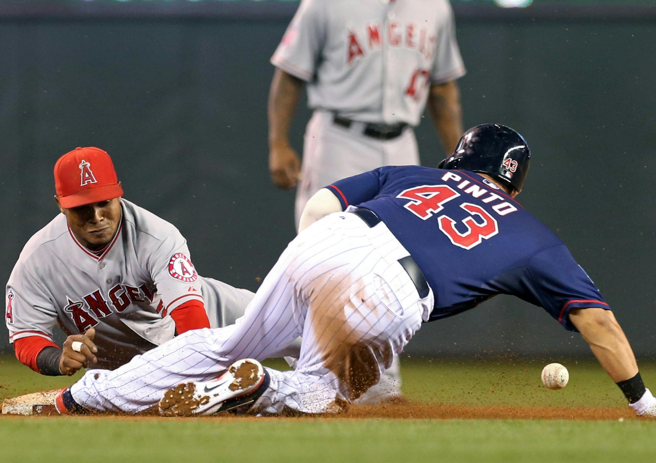 Los Angeles Angels shortstop Erick Aybar, left, cannot handle the throw as Minnesota Twins' Josmil Pinto (43) doubles off pitcher Matt Shoemaker in the fourth inning of a baseball game, Friday, Sept. 5, 2014, in Minneapolis. (AP Photo/Jim Mone)
