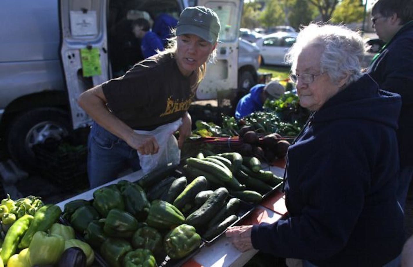 Julie Otto of Hilltop Greenhouse and Farm helped Ione Callahan pick out produce at the farmers market.