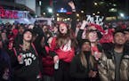 Basketball fans cheer for the Toronto Raptors before claiming victory over the Philadelphia 76ers outside Maple Leaf Square during the second half of 